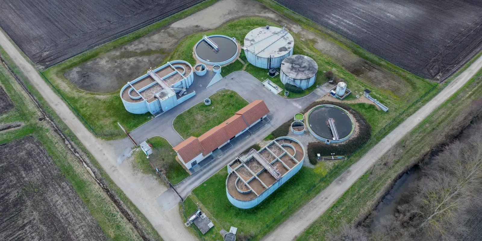 Vista aérea de una planta de tratamiento de efluentes con piletas y clarificadores circulares